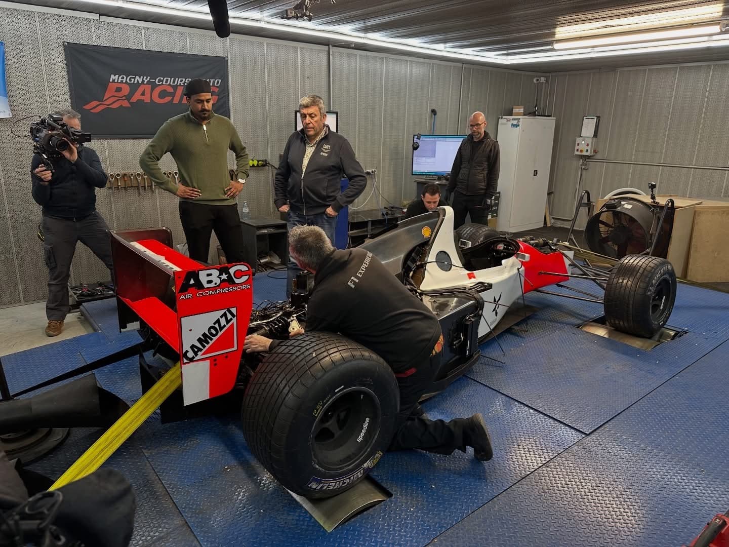 Tournage RMC Découverte à l'atelier AWD Magny-Cours : monoplace de Formule 1 historique sur le banc de puissance, filmée par une caméra pour l'émission Vintage Mécanique